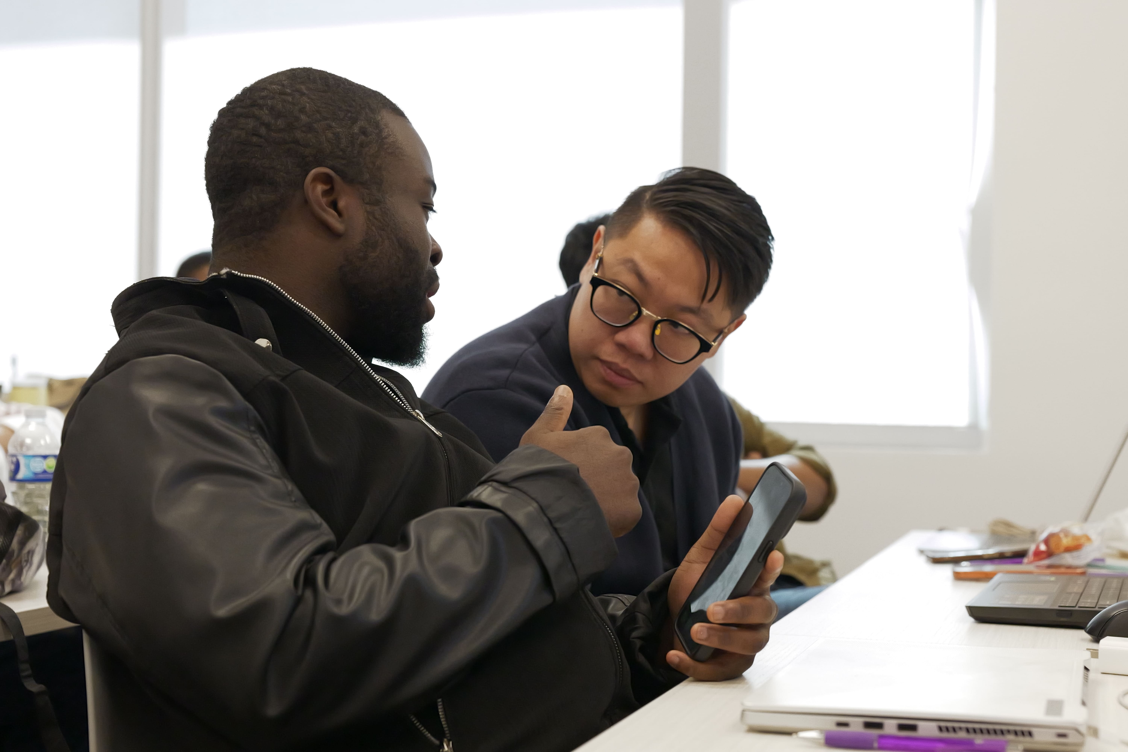 Two students discussing in class.