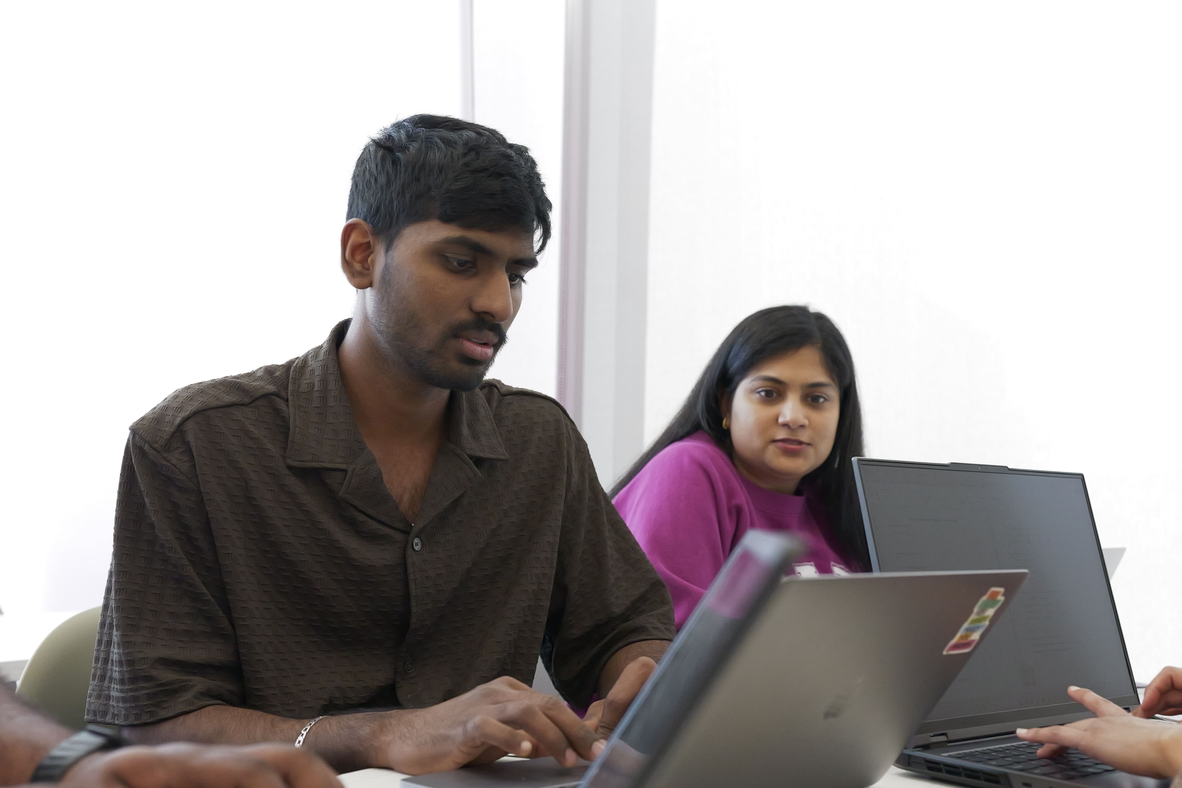 Students working on laptops in class.