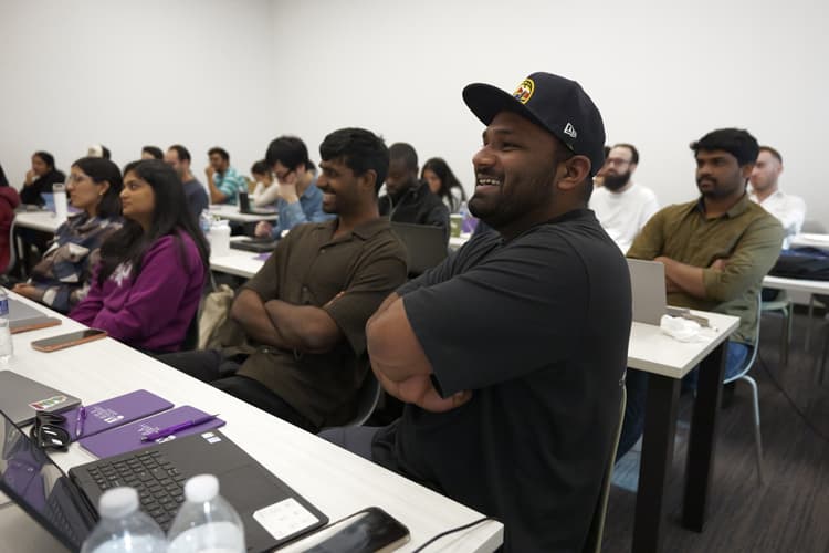 Students smiling in a classroom training session.