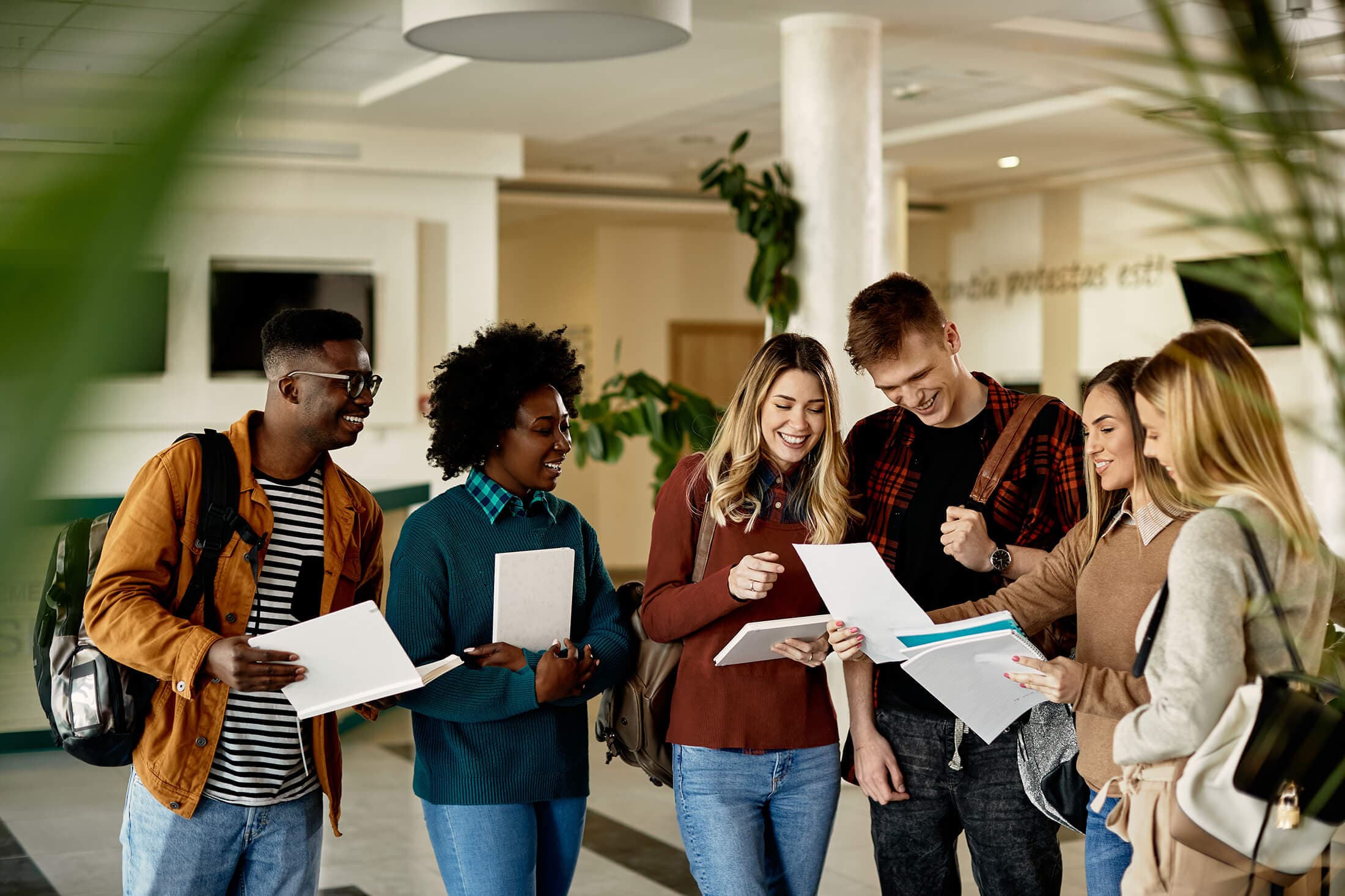 group of students looking at a paper and smiling