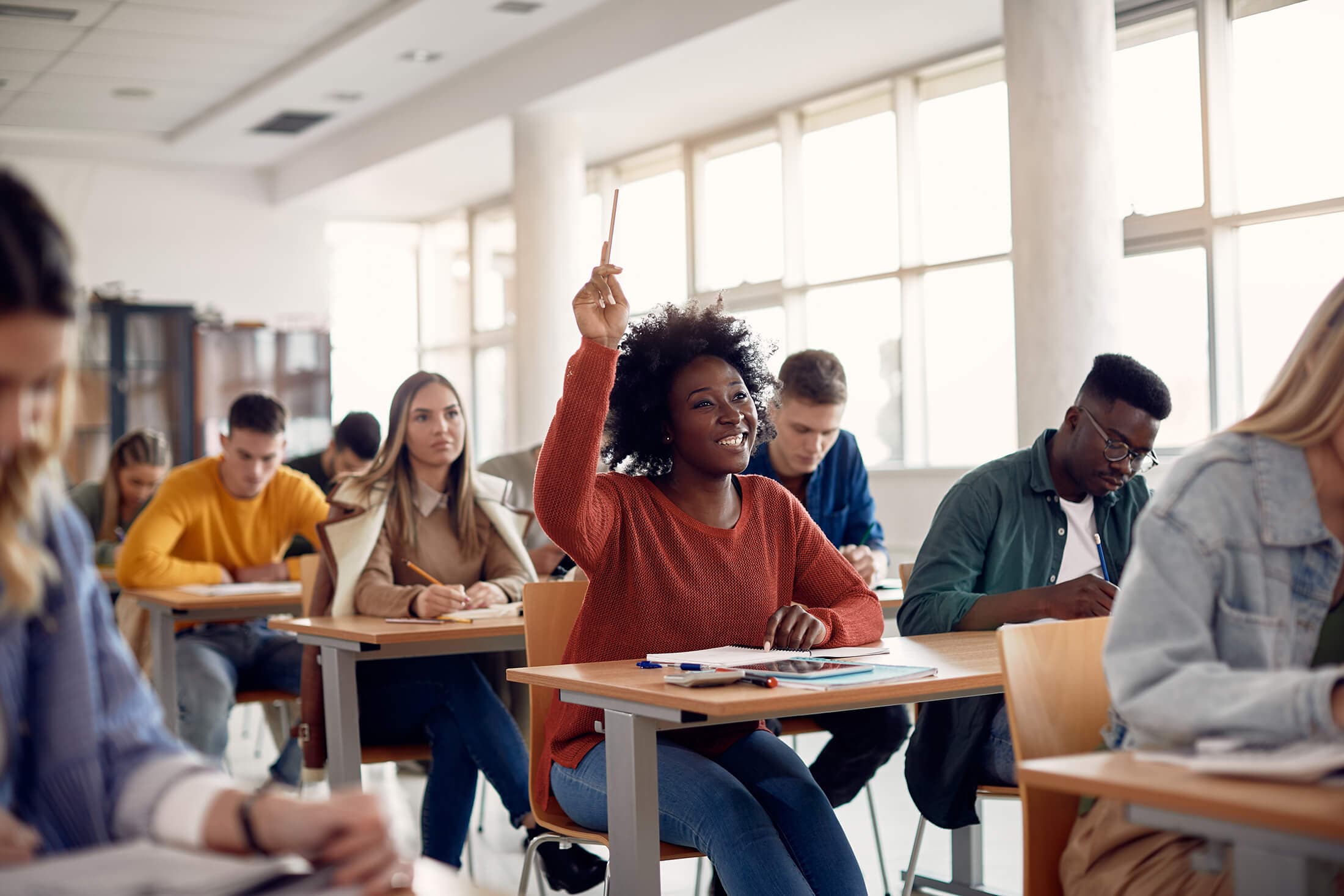 a student raising her hand in the classroom