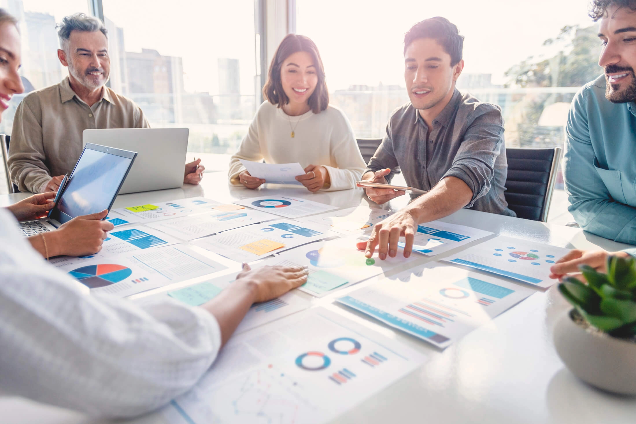 Group of people having a meeting and sharing documents and graphs