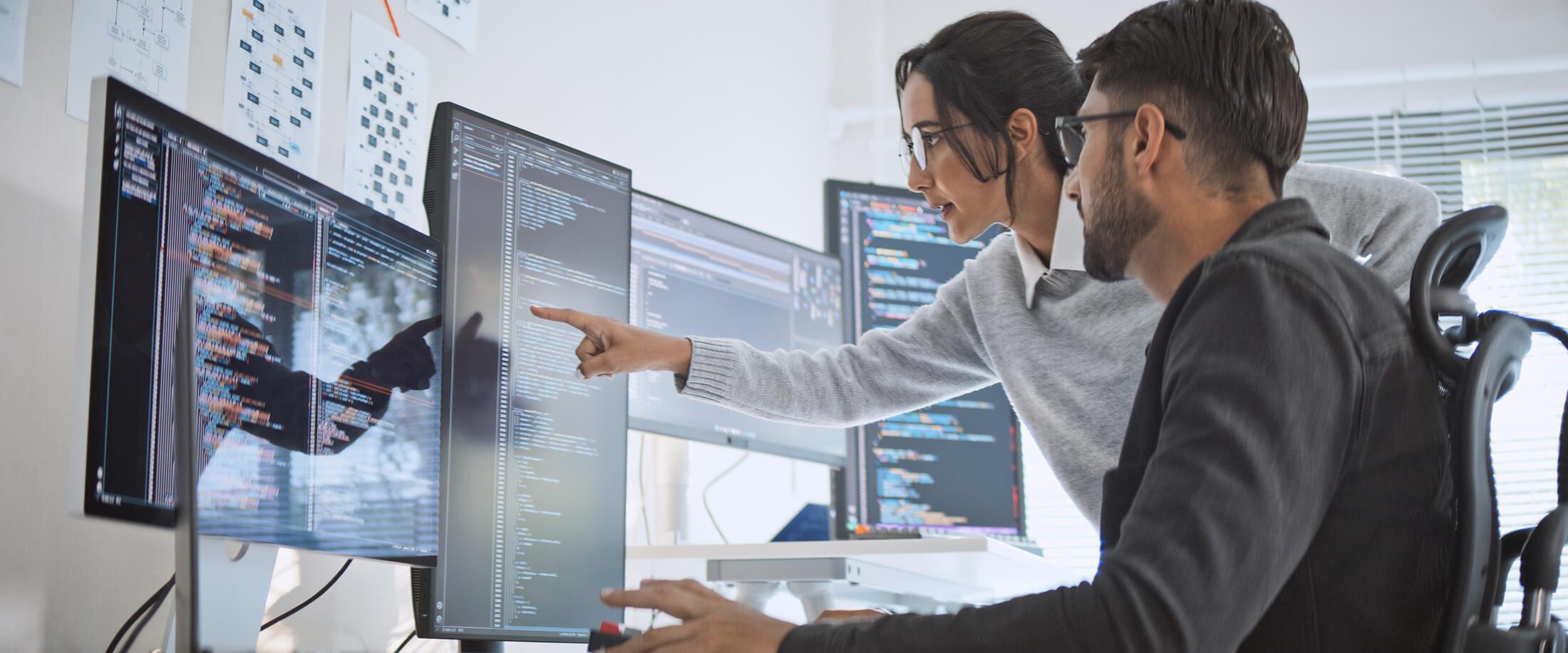 Two people looking at computer screen and chatting