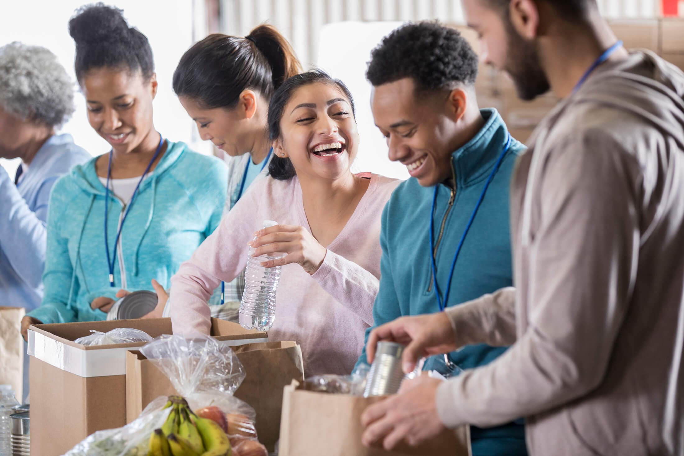 group of people helping with packaging products in a box