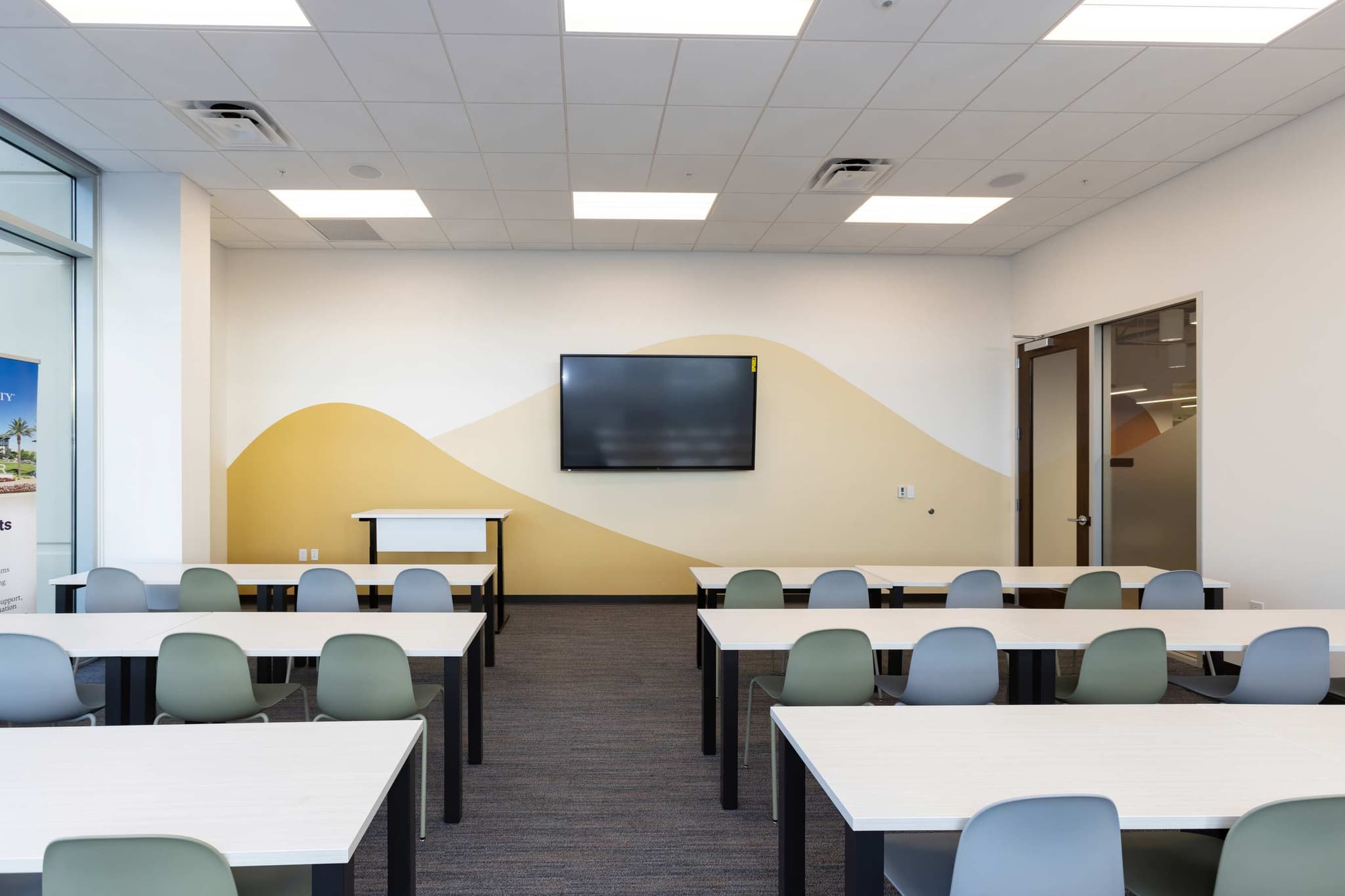 classroom with desks and wall-mounted display